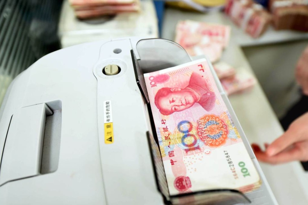 An employee counts 100 yuan banknotes at a bank in Lianyungang, Jiangsu province. Photo: AFP