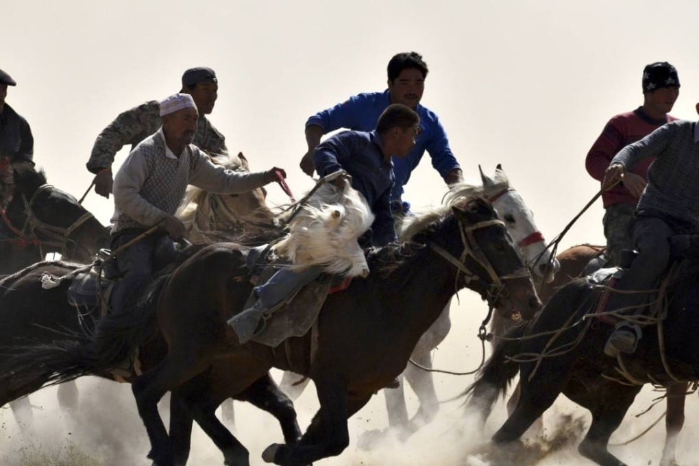 Participants ride horses as they fight for a slaughtered goat during a Buzkashi event in Yuli county, Xinjiang in 2013. Photo: Reuters