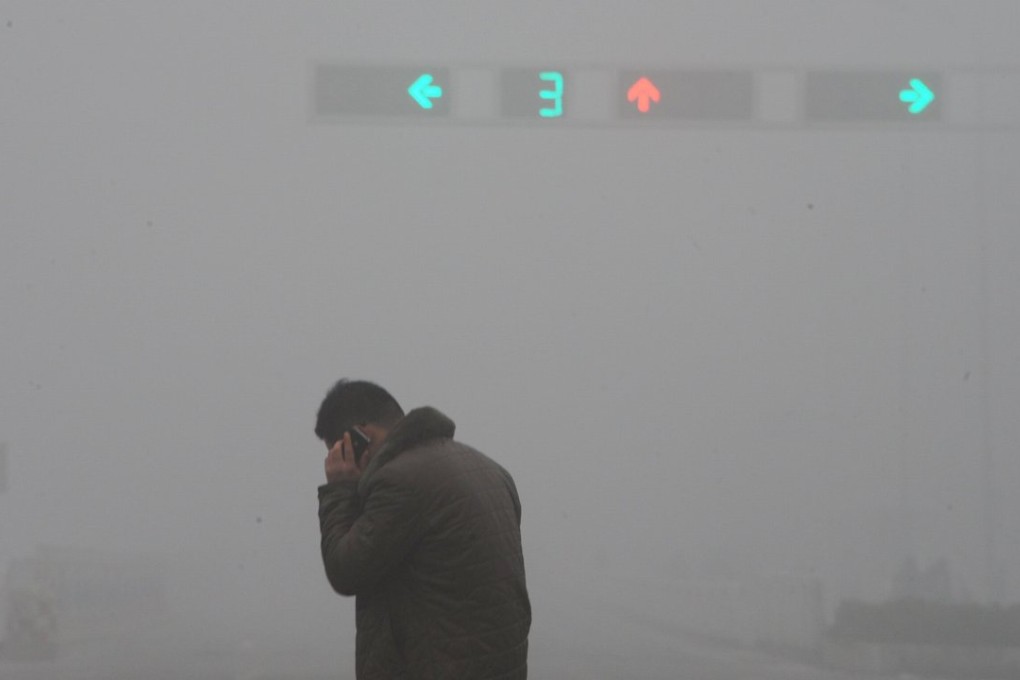 A man talks on his mobile phone at a street crossing in Bozhou, Anhui province. Photo: Reuters