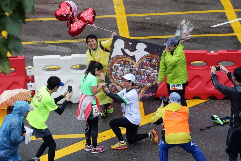 Love runs hot in the Hong Kong rain, two lovers get engaged on the sidelines of the marathon. Photo: Felix Wong