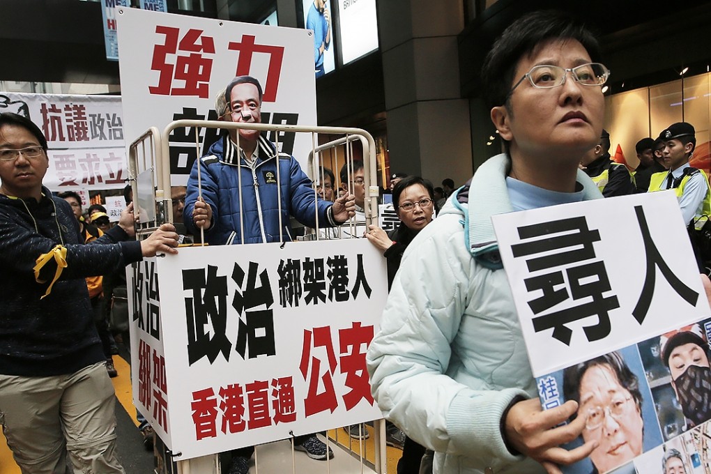 A protester wearing a mask of missing bookseller Lee Bo stands in a cage during a protest against the disappearances of booksellers in Hong Kong after five men associated with a Hong Kong publisher known for books critical of China's leaders have vanished one by one in the last three months. Photo: AP