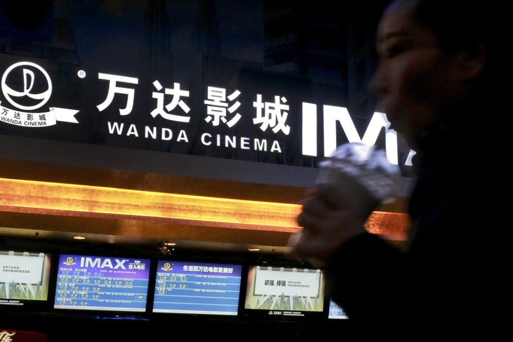 A Chinese moviegoer walks into the Wanda Cinema at the Wanda Group building in Beijing. Photo: AP
