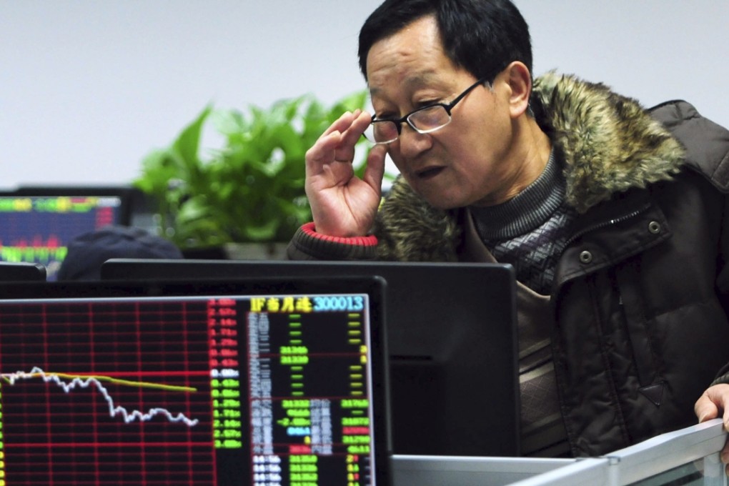 An investor checks stock prices on a computer terminal in a brokerage house in Jiujiang, Jiangxi province, on Friday. Photo: AP
