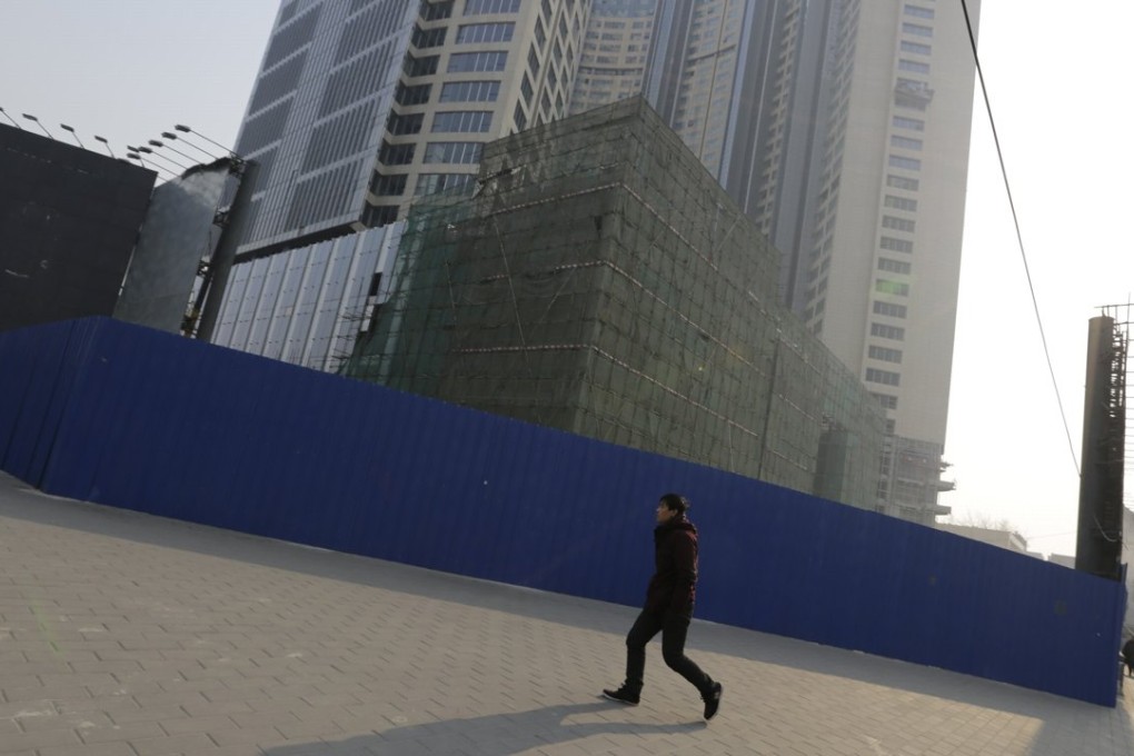 A man walks past a construction site in Beijing. Photo: Reuters