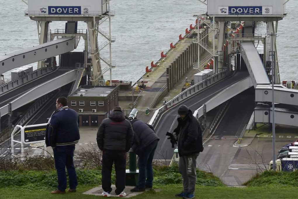 Men look across the English Channel towards France through a telescope at the Port of Dover in Britain. Photo: Reuters