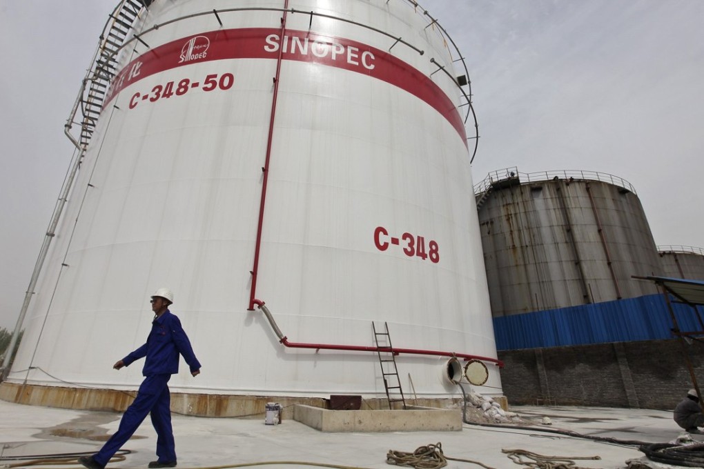 An employee walks past oil tanks at a Sinopec refinery in Wuhan, Hubei province. Photo: Reuters
