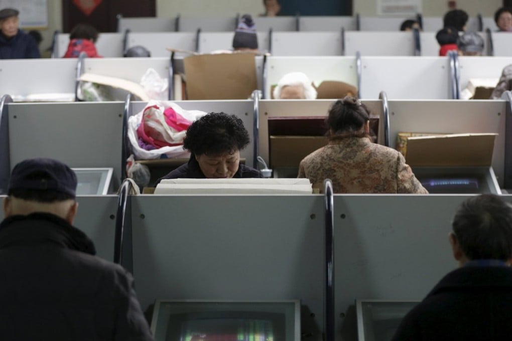 Investors look at computer screens showing stock information at a brokerage house in Shanghai. Photo: Reuters