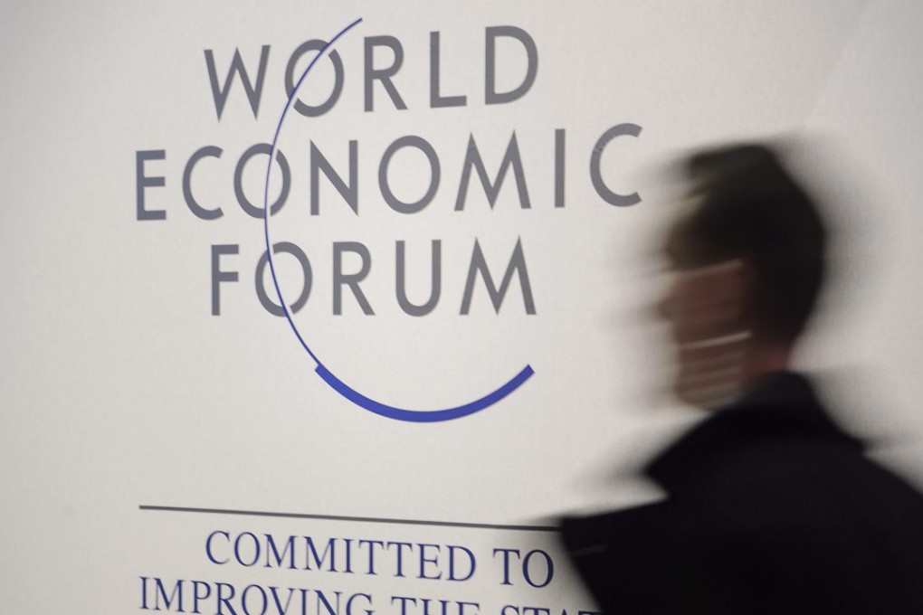 A man walks past a logo at the World Economic Forum in Davos, Switzerland. Photo: EPA