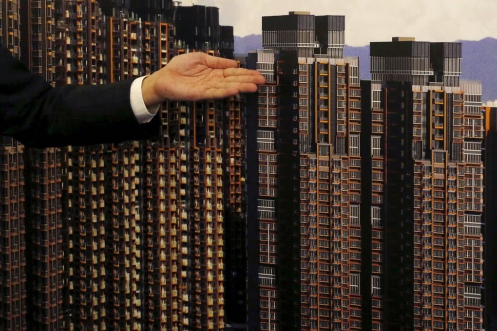 A representative from a developer poses in front of a backdrop during the promotional event of a new flat in Hong Kong on March 20. Photo: Reuters