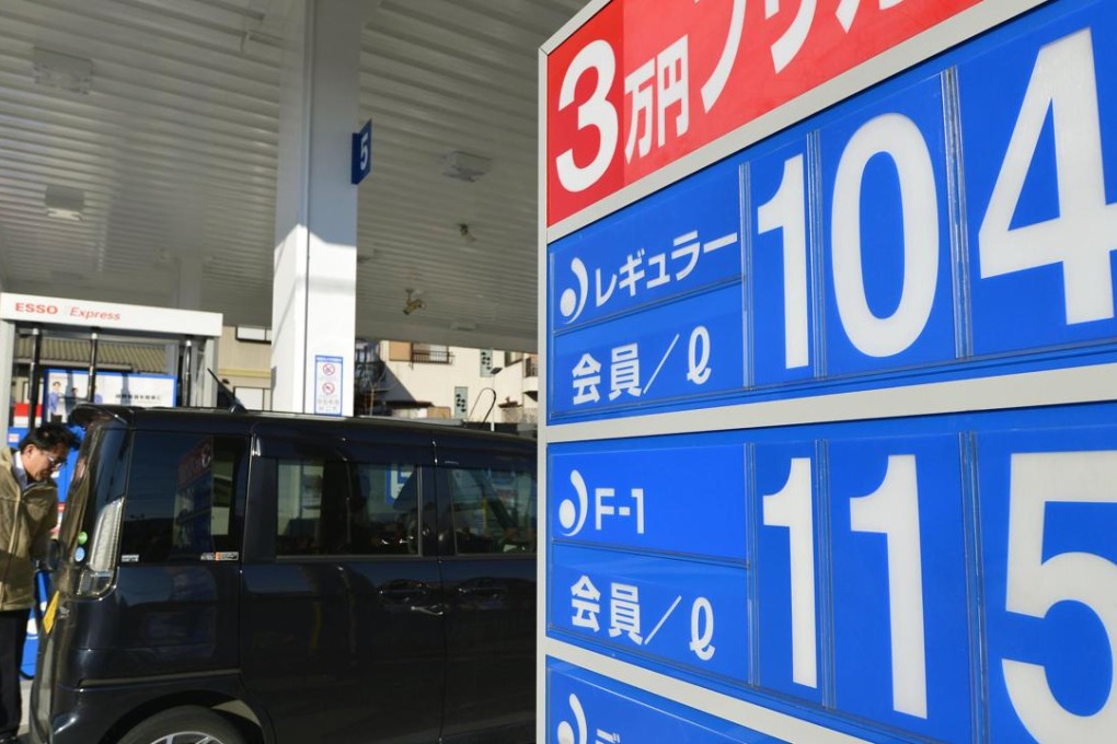 A display at a gas station in Osaka shows regular petrol priced at 104 yen a litre on January 14, the day the retail price in Japan dropped below 119 yen for the first time since May 2009. Photo: Kyodo