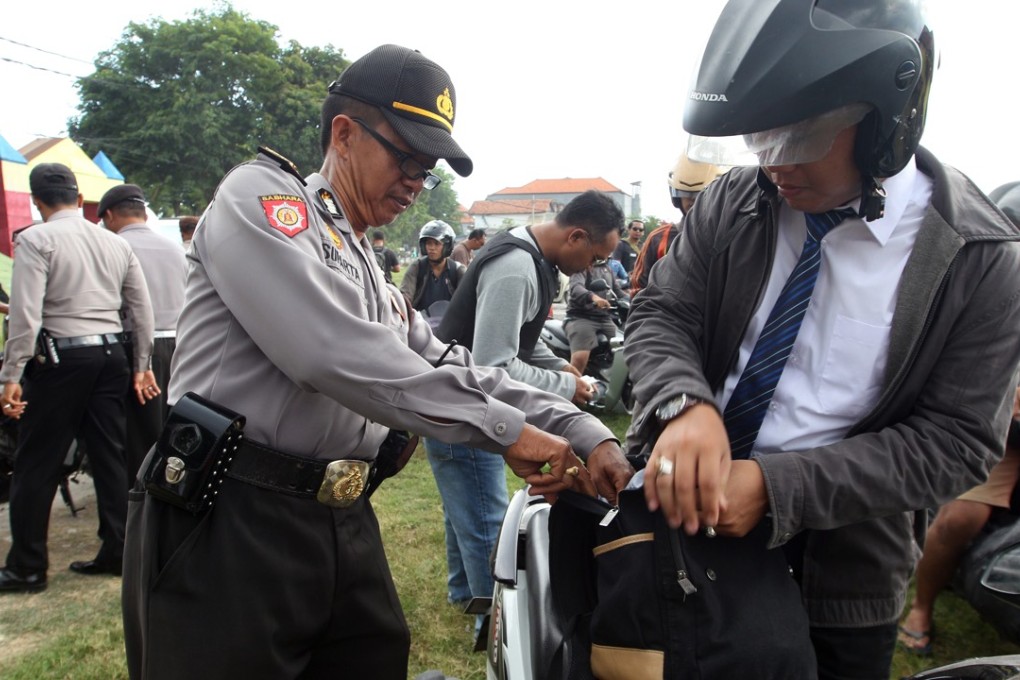 Police officers checked motorcyclists at a security check point in Bali, Indonesia. Photo: AP