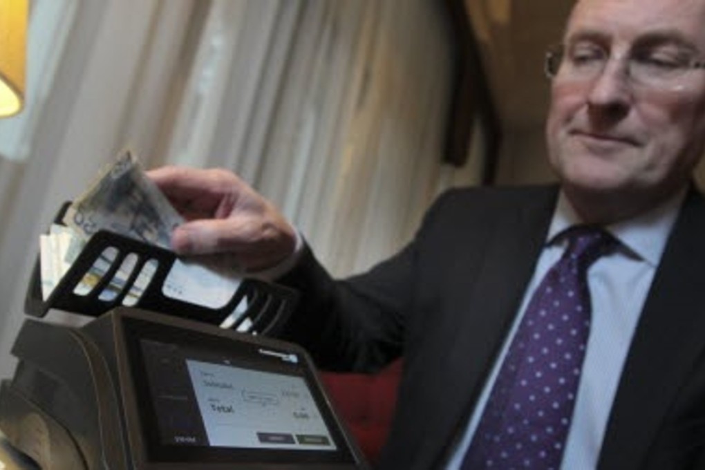 Gordon McKie, chief executive of Cashmaster International, poses for a photograph with the Cashmaster One Plus counting maching in Causeway Bay, Hong Kong on Friday. Photo: Bruce Yan