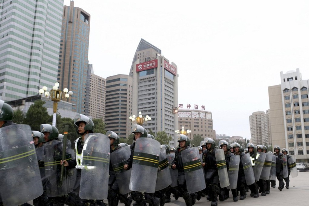 Armed paramilitary policemen run in formation during a gathering to mobilise security operations in Urumqi, Xinjiang, in 2013. Photo: Reuters