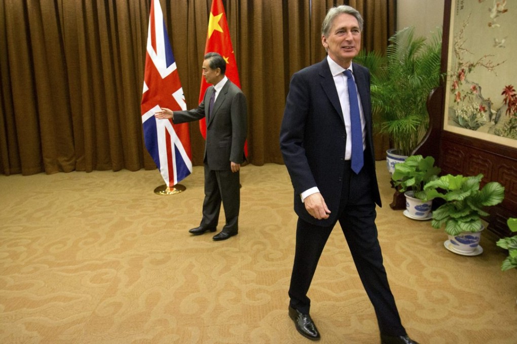 British Foreign Secretary Philip Hammond (right) makes his exit after shaking hands with Foreign Minister Wang Yi in Beijing. Photo: EPA