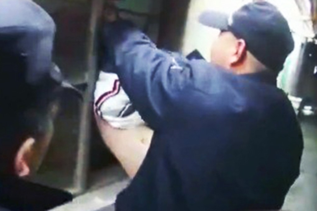 Police try to free the burglar from the window bars. Photo: SCMP Pictures