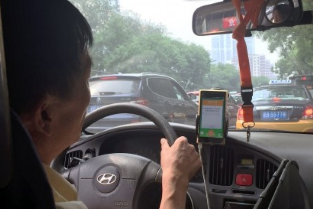 A taxi driver in Beijing takes a request from the taxi-hailing app Did Kuaidi. Photo: Simon Song