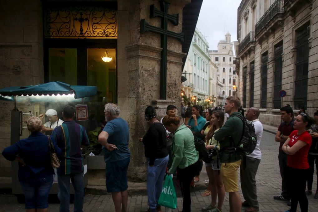 Tourists and Cubans line up for fried dough in old Havana. Photos: Reuters