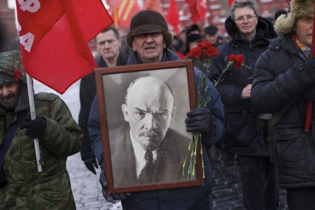 Pro-Communist Muscovites hold Soviet flags and a portrait of the Soviet founder Vladimir Lenin, as they walk to visit the mausoleum of Lenin to mark the 92th anniversary of his death in Red Square last Thursday. Photo: AP