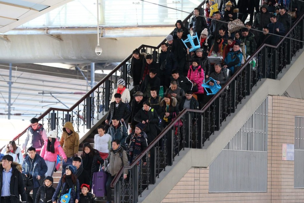 Chinese passengers carry their bags towards the platform at Beijing railway station on the first day of Chunyun. Photo: EPA