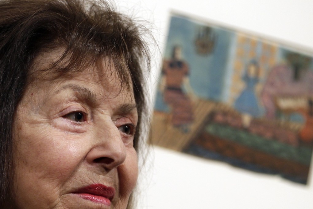 Artist Nelly Toll in front of one of her paintings at the exhibition ‘Art from the Holocaust’. Photo: AP