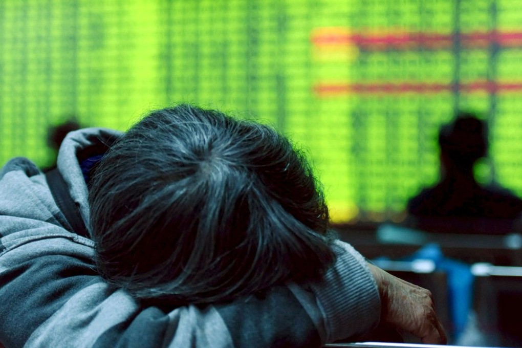 An investor rests in front of an electronic screen showing stock information at brokerage house in Hangzhou, Zhejiang province. Photo: Reuters