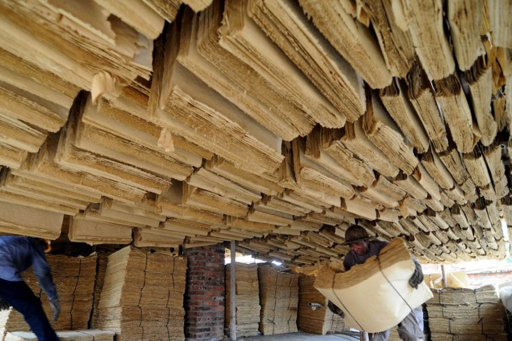A 2009 file photo showing workers conveying bundles of impounded paper at an illegal paper mill in Xiliu Village in Liubei District of Liuzhou, southwest China's Guangxi Zhuang Autonomous Region. Photo: Xinhua