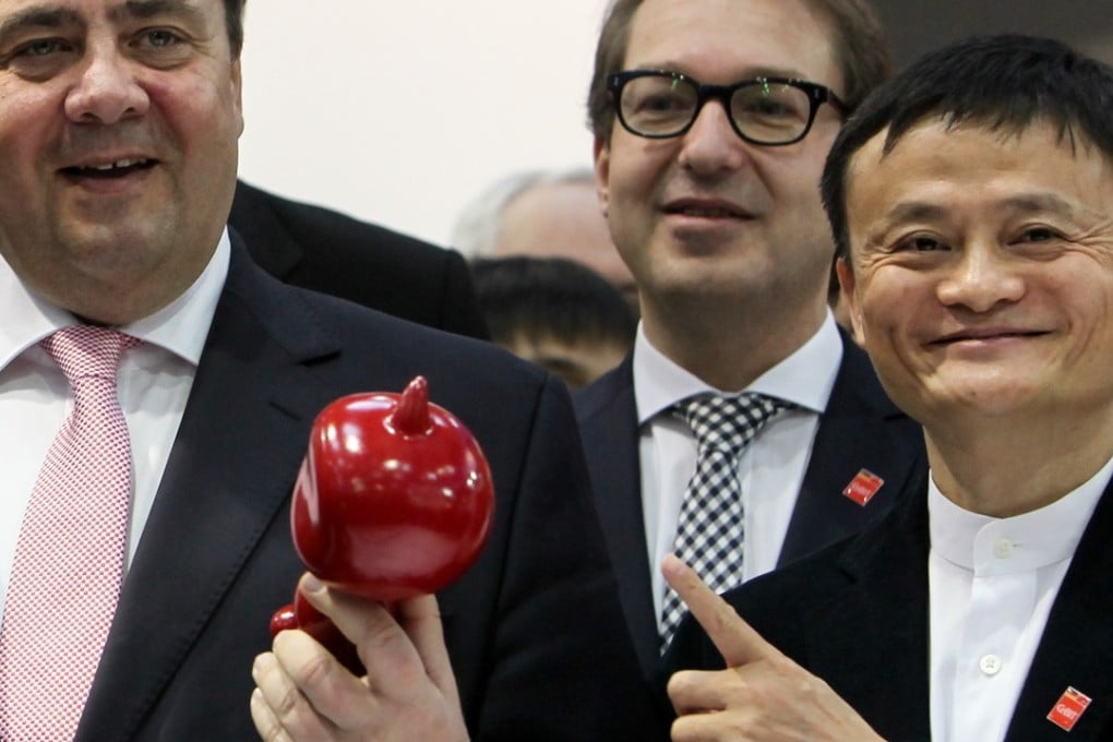 Alibaba chaiman Jack Ma points to a doll at a fair in Germany as his company announced a huge jump in its quarterly results on Thursday. Alibaba recently bought the South China Morning Post. Photo: Xinhua