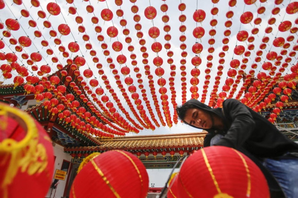 A temple maintenance worker prepares traditional Chinese lanterns for the Lunar New Year celebrations in Kuala Lumpur, Malaysia. Photo: AP