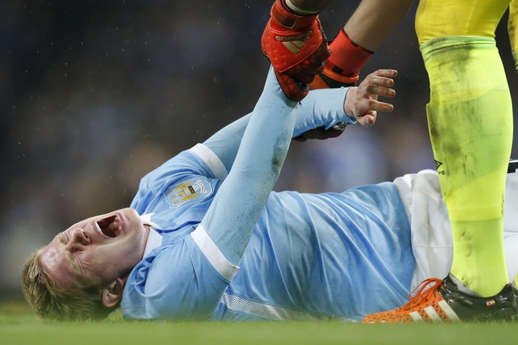 Kevin de Bruyne feels the pain before being stretchered off. Photo: AP