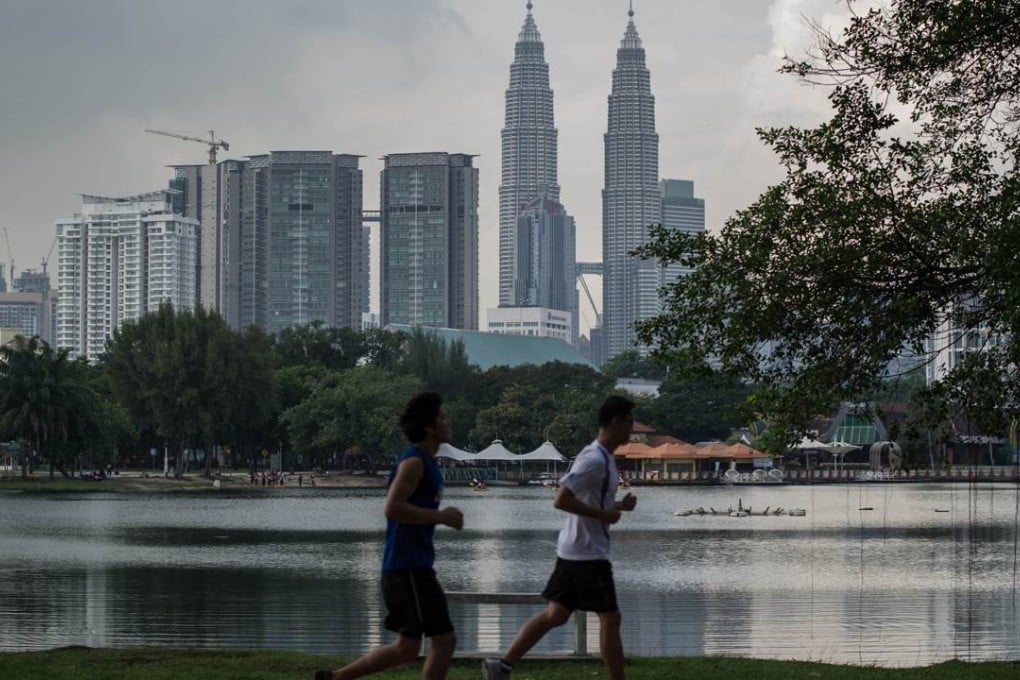 People jog in a Kuala Lumpur park across from Malaysia's landmark Petronas Twin Towers. Photo: AFP