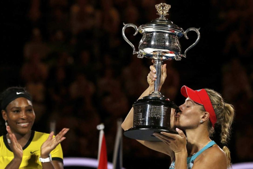 Germany's Angelique Kerber kisses the trophy as Serena Williams of the US applause after Kerber won their final match at the Australian Open. Photo: Reuters