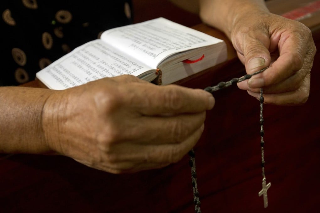 A devotee holds rosary beads as she prays during a vigil in a Catholic church in China’s eastern Zhejiang province. Photo: AP
