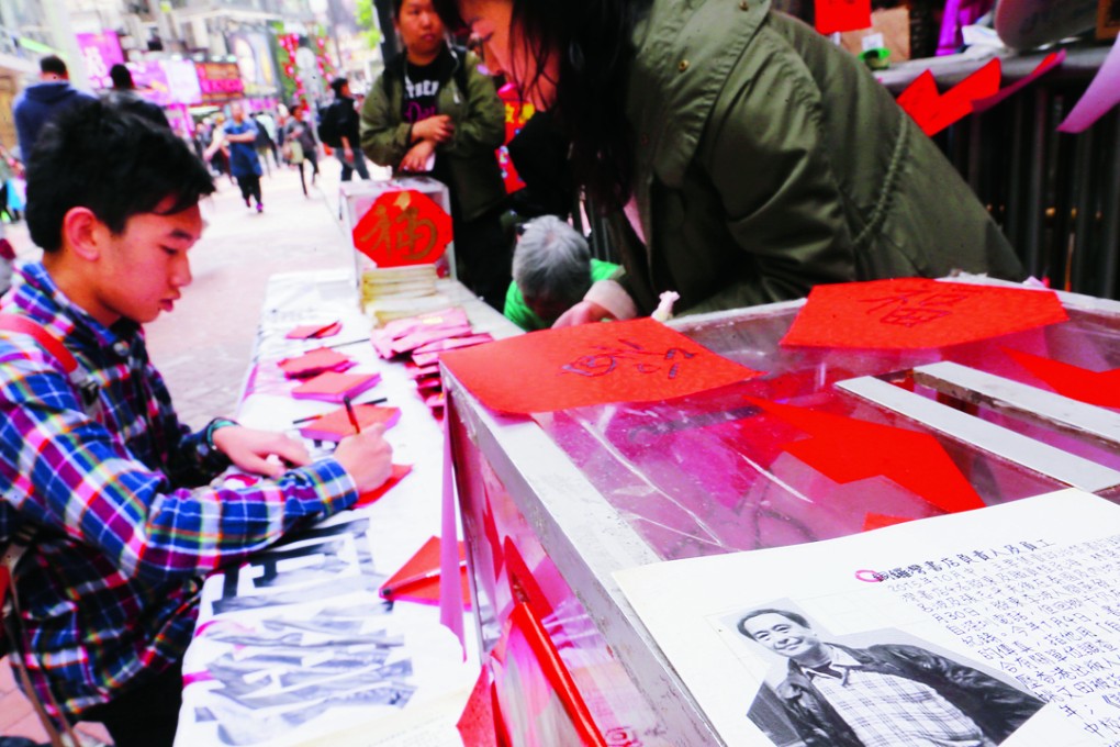 A man writes a message in support of missing bookseller Hong Kong Lee Po and his four associates at a street booth in Causeway Bay. Photo: Dickson Lee