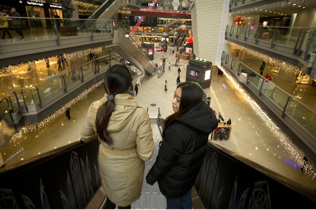 People ride an escalator in an upmarket shopping mall in Beijing. Photo: AP