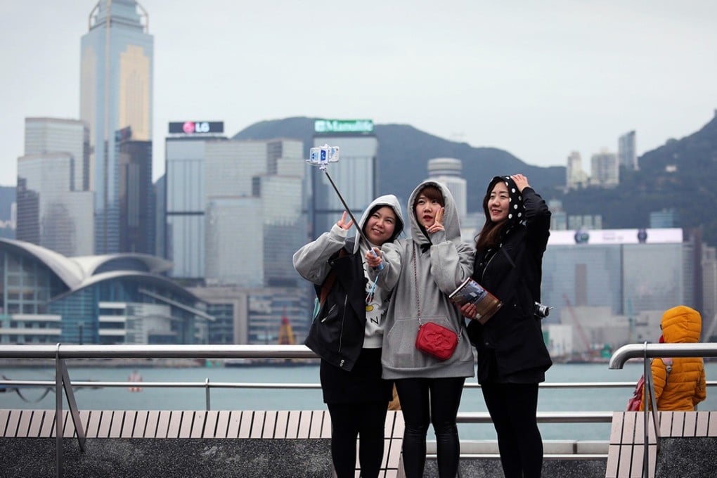 Three girls take a selfie on a viewing deck next to Victoria Harbour. Hong Kong experienced its coldest day in 59 years last week, with temperatures plunging to 3 degrees in urban areas. Photo: AFP