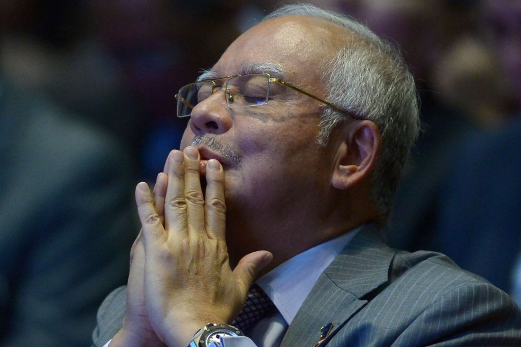 Malaysian Prime Minister Najib Razak offering prayers before addressing journalists during a budget review session in Putrajaya. Photo: AFP