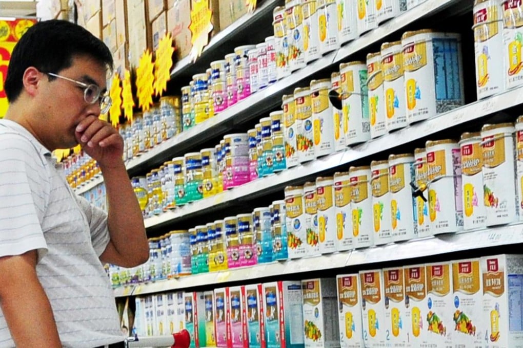 A Chinese man selects milk powder at a supermarket in Beijing as ChemChina is reportedly on the verge of buying Swiss seed giant Syngenta. Photo: AFP