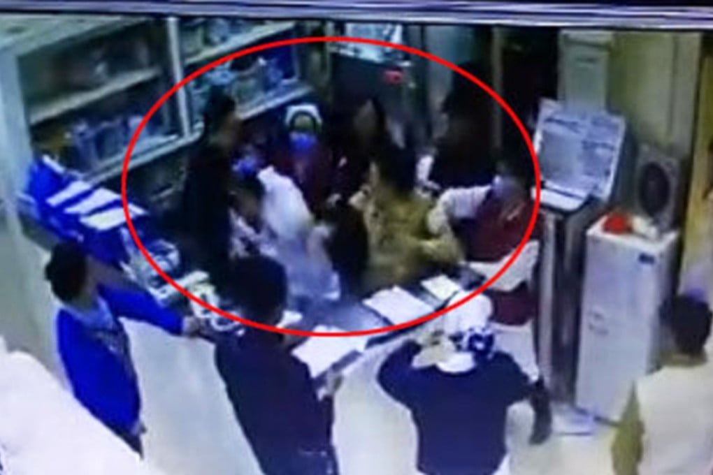 One of Wang’s relatives, in yellow coat, wades into staff in the emergency department. Photo: SCMP Pictures
