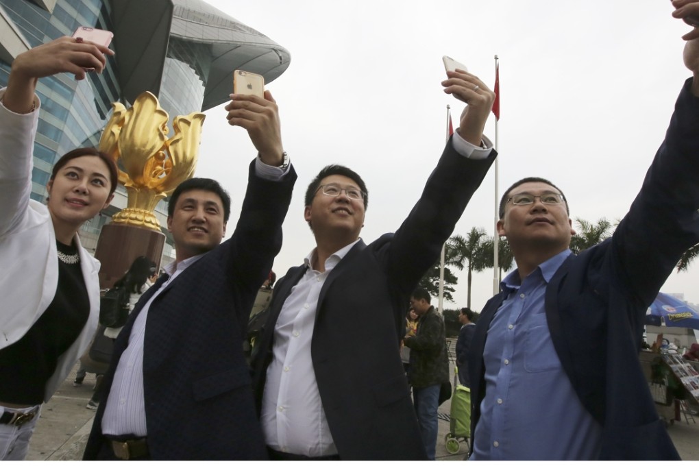 Tourists from Harbin take selfies at Golden Bauhinia Square. Photo: Edward Wong