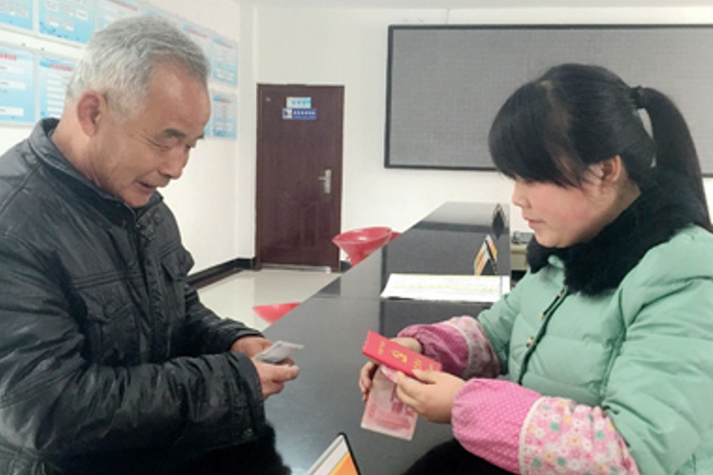 A Communist Party member pays her fees in person, just as the latest advice suggests. File Photo