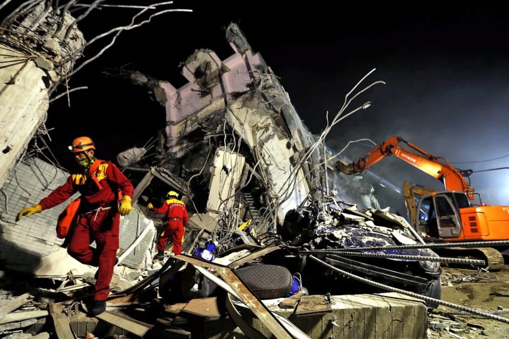 Rescuers remove debris as they continue to search for survivors from a collapsed building in Tainan late into the night. Photo: EPA