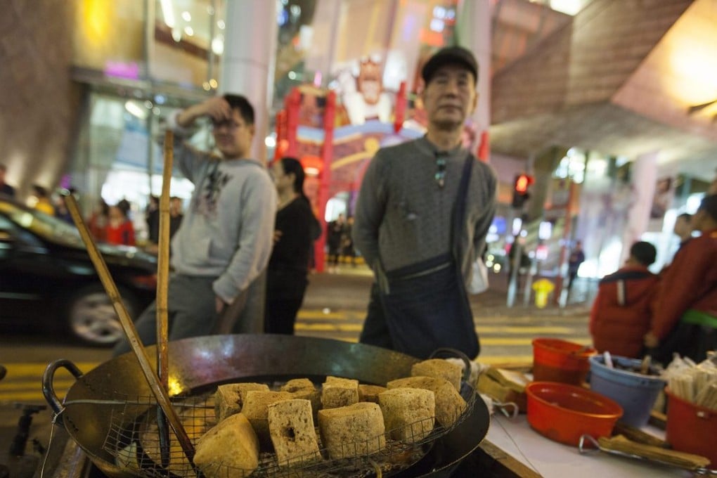 A street hawker sells 'stinky tofu' in Portland Street, Mong Kok, after the previous night's violent clashes between police and protesters. Photo: EPA