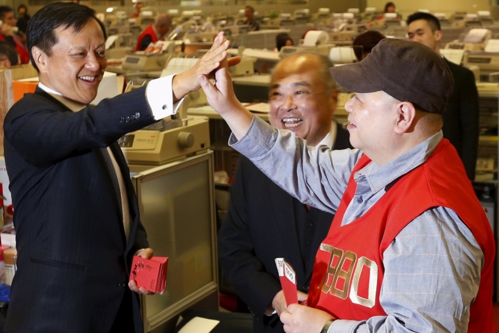 HKEx chief executive Charles Li (left) congratulates a floor trader who received red packets yesterday as HKEx chairman Chow Chung-kong (centre) looks on. Photo: Reuters