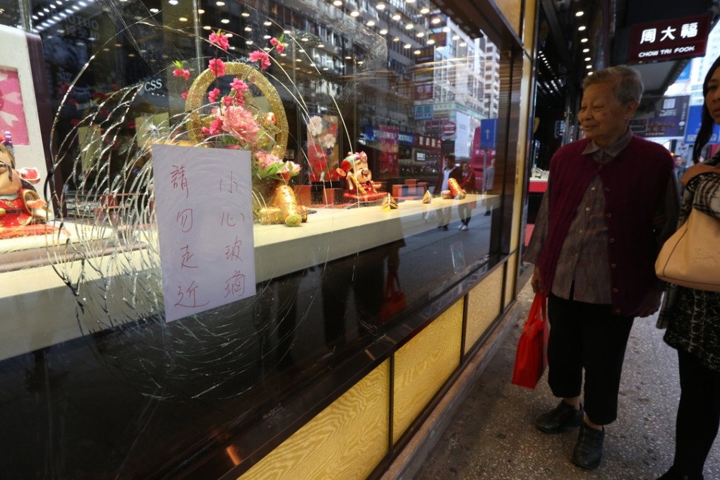 People walk past a jewellery shop window that sustained partial damaged in the overnight clashes between protesters and police in the Mong Kok. Photo: Nora Tam