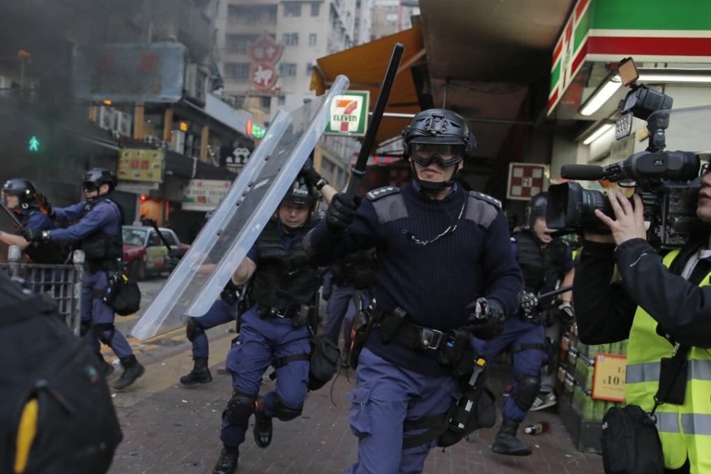 Riot police move toward protesters on a street in Mong Kok during chaotic scenes with protesters and police. Photo: AP