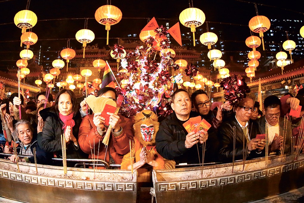 Worshippers including ex-actress Lana Wong Hai-wai (centre) dressed in monkey costume offer the first incense at Wong Tai Sin Temple on Lunar New Year's Eve. 07FEB16 SCMP/Nora Tam