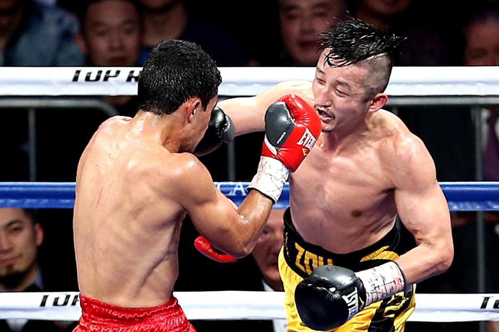 China’s Zou Shiming (right) slugs it out against Brazilian Natan Santana Coutinho on his way to an eighth-round TKO in their WBO international flyweight title bout in Shanghai. Photo: Xinhua