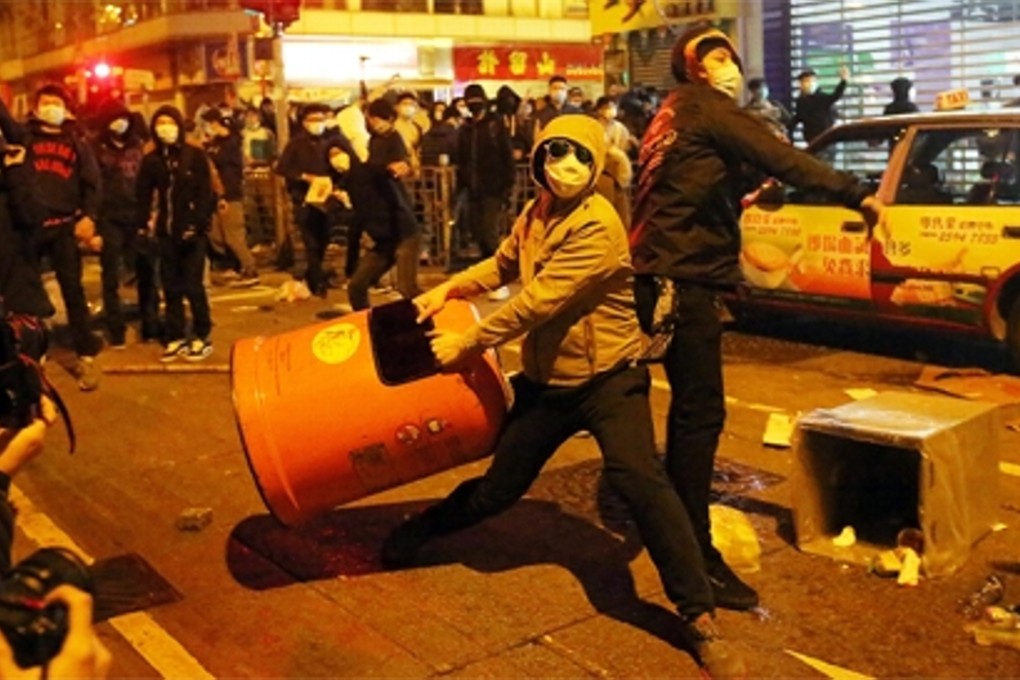 Masked rioters in Mong Kok during a clash that began with a dispute over street vendors in the area. Photo: Edward Wong