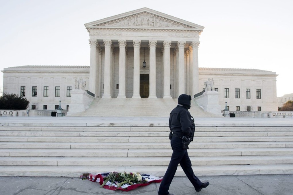 A policeman walks past flowers and candles outside the US Supreme Court in Washington where Scalia served. Photo: EPA