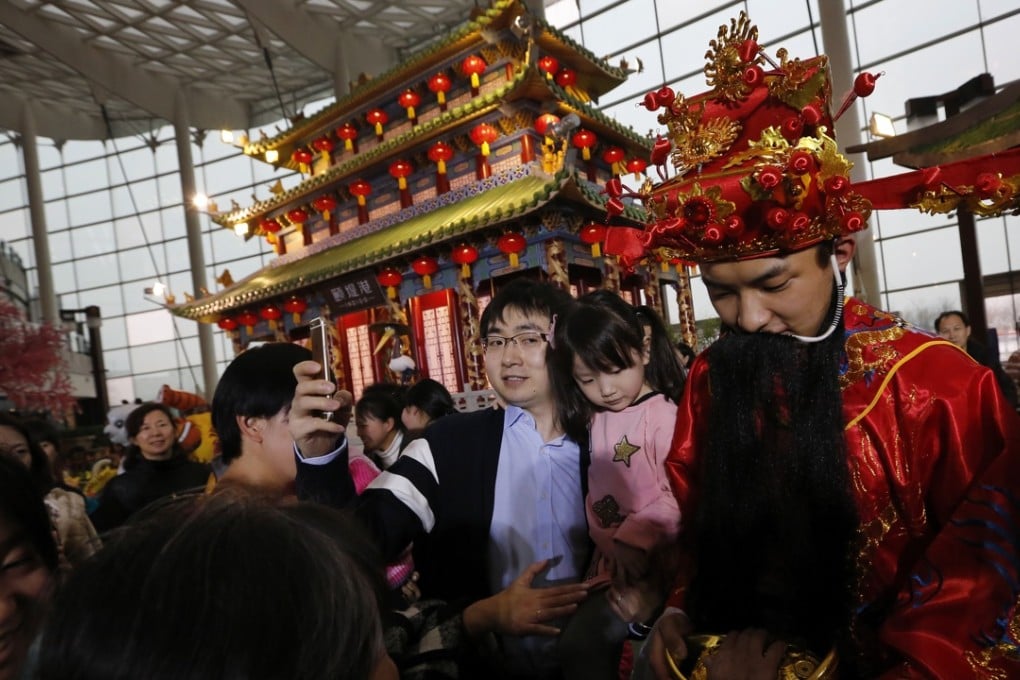 A man takes a selfie at a shopping mall in Beijing, as a crowd celebrates the Year of the Monkey. Photo: AP